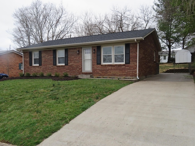 single story home featuring a front yard, brick siding, and driveway