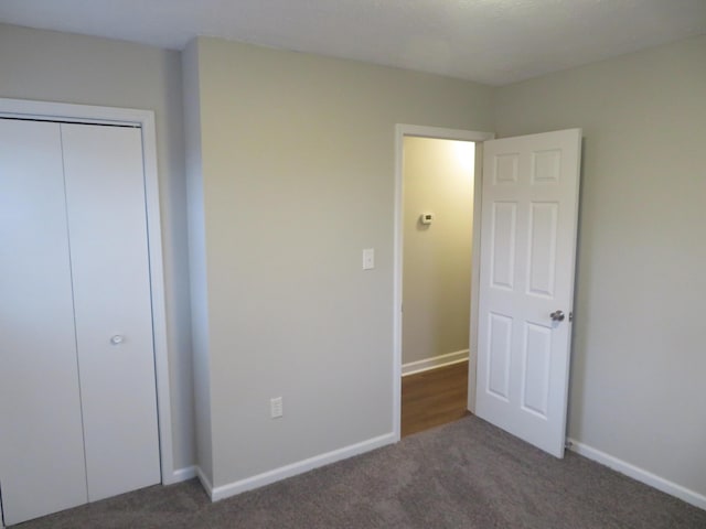 unfurnished bedroom with a closet, baseboards, and carpet flooring