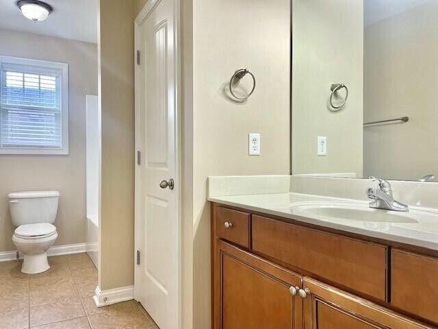 bathroom featuring tile patterned floors, baseboards, toilet, and vanity