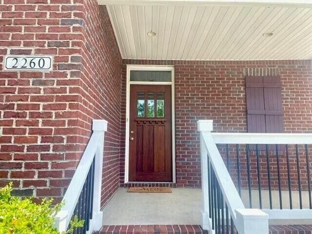 doorway to property with brick siding