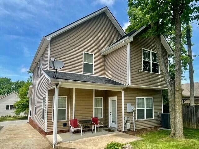 back of house featuring a porch, central AC, and fence