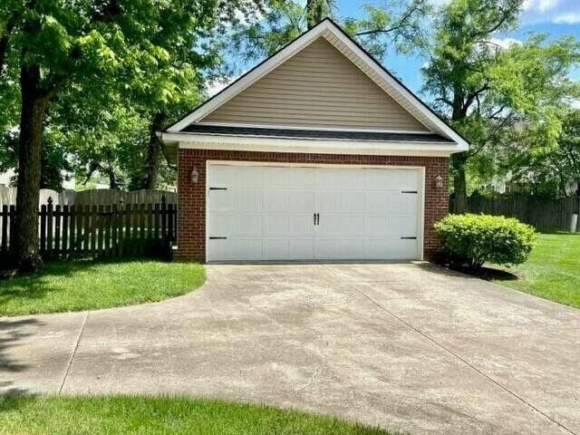 garage with driveway and fence