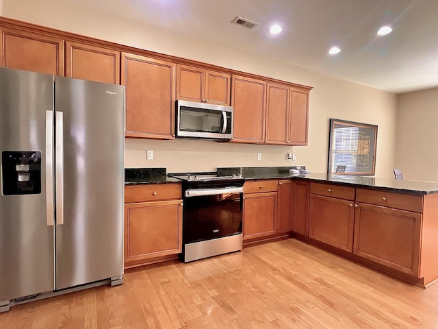 kitchen featuring visible vents, a peninsula, recessed lighting, appliances with stainless steel finishes, and light wood-type flooring