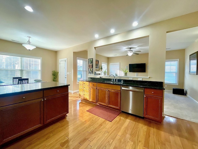 kitchen with open floor plan, light wood-style flooring, dishwasher, and a sink