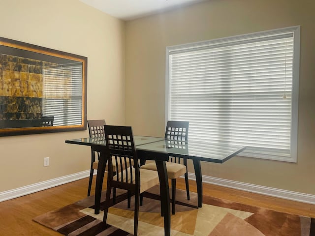 dining space with wood finished floors and baseboards