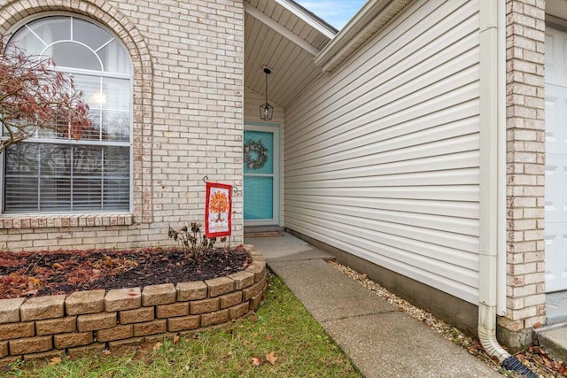 view of exterior entry featuring brick siding