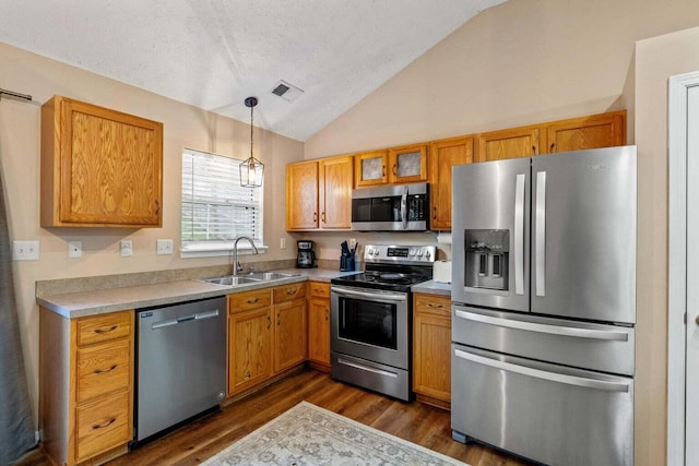 kitchen featuring visible vents, a sink, appliances with stainless steel finishes, light countertops, and lofted ceiling