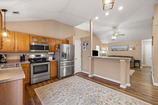 kitchen with visible vents, a sink, open floor plan, appliances with stainless steel finishes, and light countertops