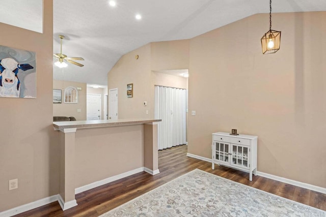 kitchen featuring baseboards, wood finished floors, a ceiling fan, and vaulted ceiling