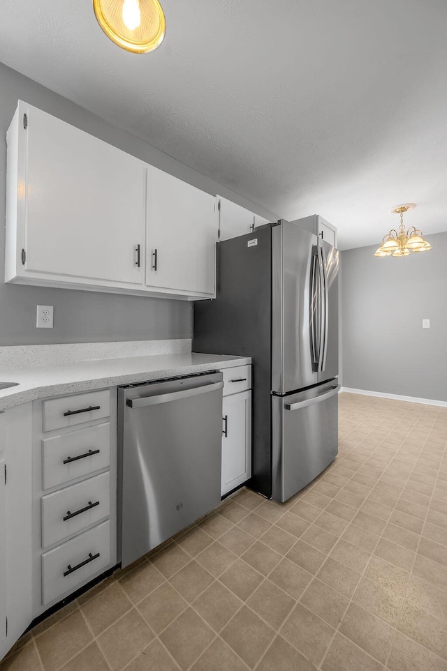 kitchen with baseboards, light countertops, appliances with stainless steel finishes, an inviting chandelier, and white cabinetry