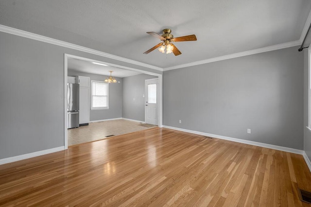 spare room featuring baseboards, ceiling fan with notable chandelier, ornamental molding, and light wood finished floors
