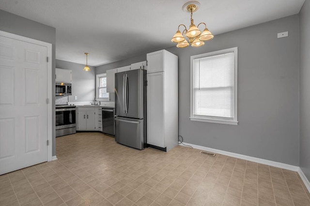 kitchen featuring visible vents, a notable chandelier, a sink, stainless steel appliances, and baseboards