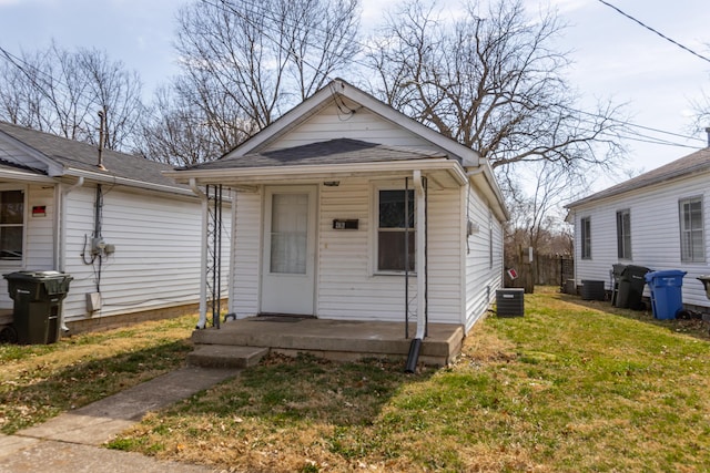 416 Ash St, Lexington, KY 40508 - shotgun-style home featuring cooling unit, covered porch, and a front lawn