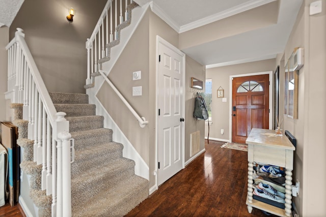foyer featuring ornamental molding, dark wood-type flooring, stairway, and baseboards
