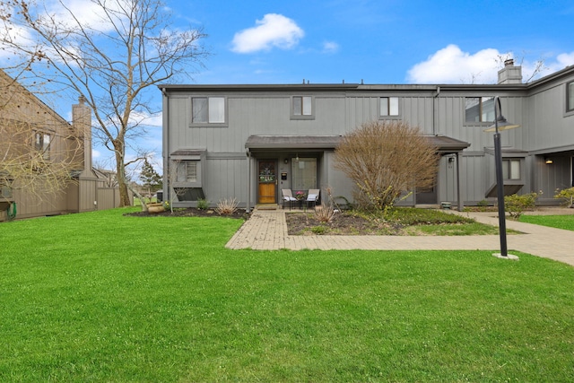 back of property with a lawn