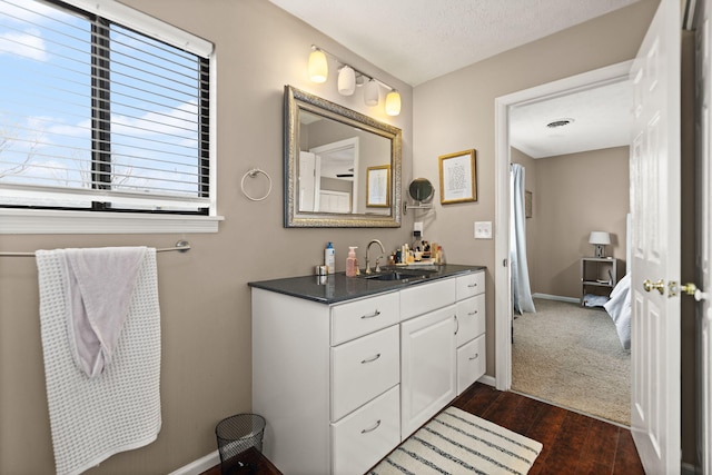 bathroom with baseboards, visible vents, wood finished floors, and vanity