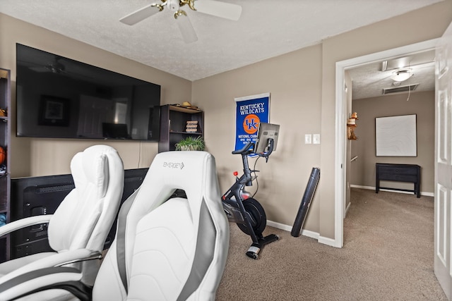 exercise area featuring a textured ceiling, visible vents, carpet flooring, and a ceiling fan
