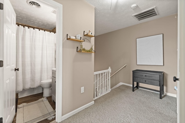 full bathroom featuring a shower with curtain, a textured ceiling, and visible vents