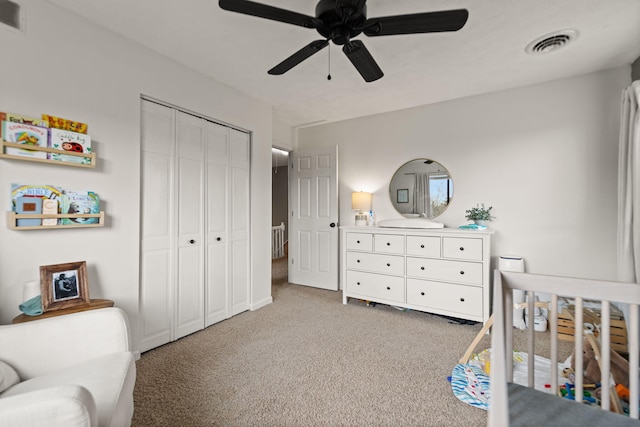 bedroom featuring a closet, ceiling fan, visible vents, and light colored carpet