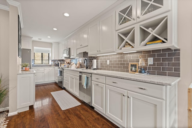 kitchen featuring white cabinetry, decorative backsplash, a sink, and stainless steel appliances