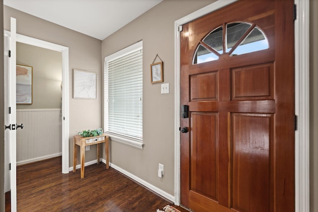 foyer entrance with dark wood finished floors and baseboards