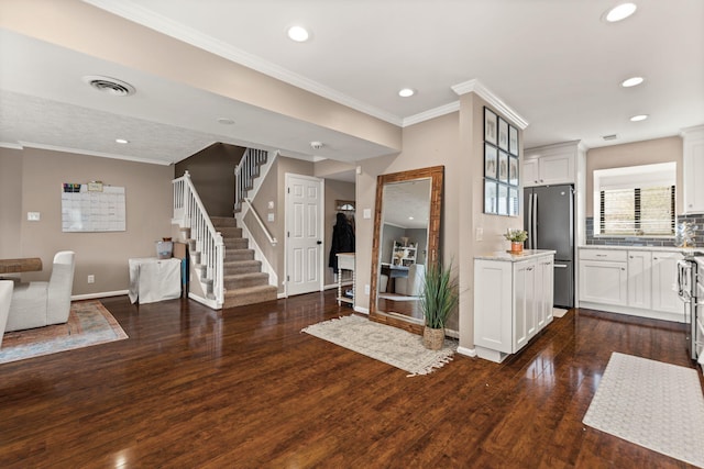 entryway featuring stairway, baseboards, visible vents, ornamental molding, and dark wood-style flooring