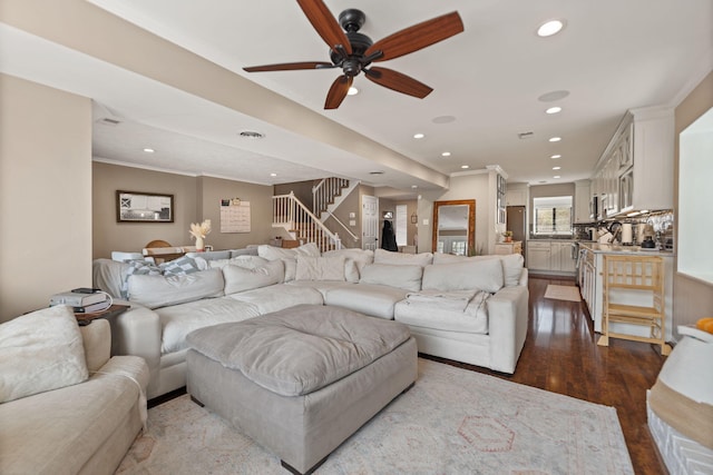 living area with recessed lighting, dark wood-style floors, stairway, and crown molding