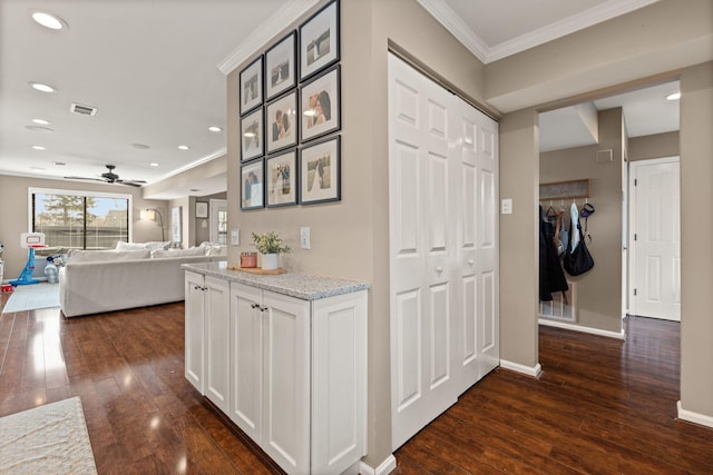 hall featuring crown molding, recessed lighting, baseboards, dark wood-style floors, and visible vents