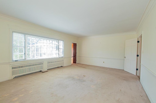 carpeted spare room with radiator heating unit and crown molding
