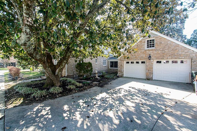 view of front of property featuring stone siding and concrete driveway