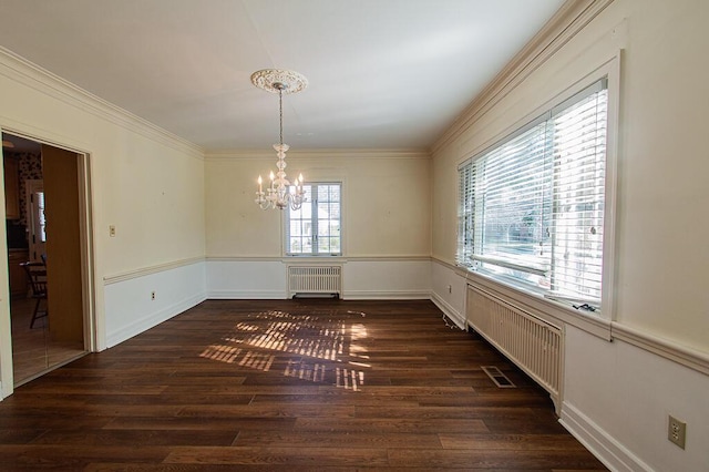 unfurnished dining area with radiator heating unit, visible vents, dark wood-type flooring, crown molding, and a chandelier