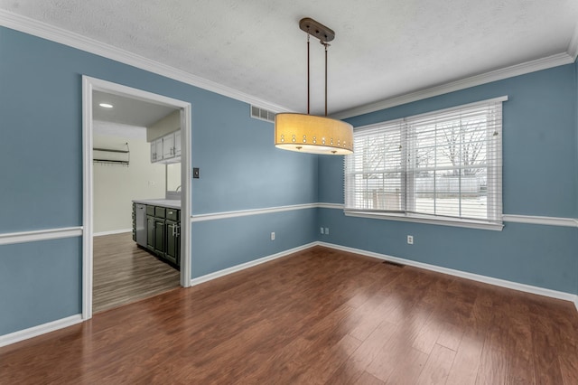 unfurnished room featuring visible vents, baseboards, ornamental molding, wood finished floors, and a textured ceiling