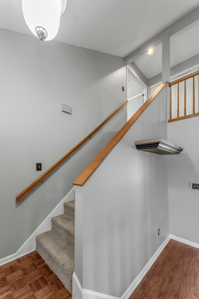 staircase with parquet floors and baseboards