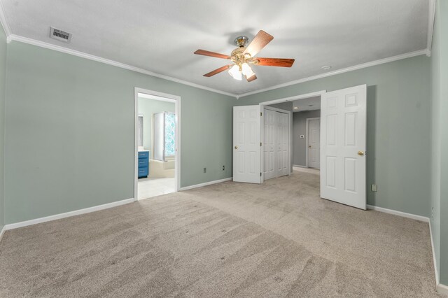 unfurnished bedroom with visible vents, baseboards, light colored carpet, and ornamental molding