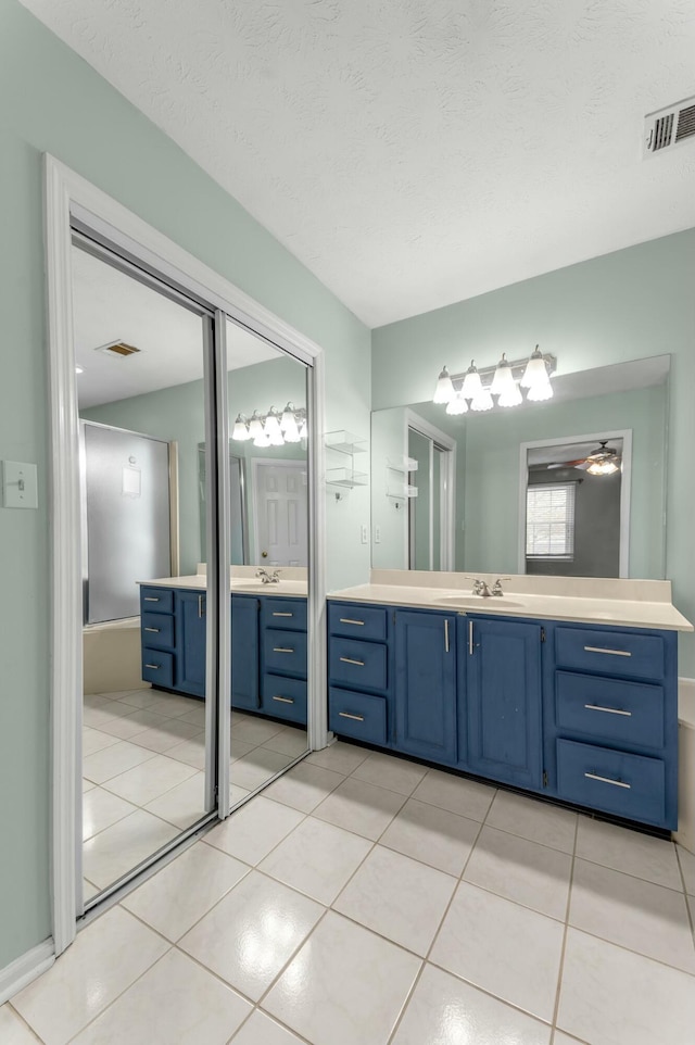 bathroom featuring tile patterned floors, visible vents, two vanities, and a sink