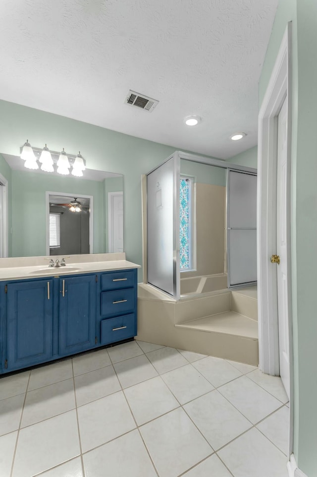 full bath featuring vanity, visible vents, a bathing tub, tile patterned flooring, and a textured ceiling