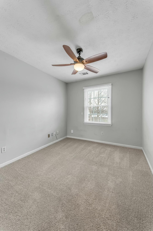 empty room featuring visible vents, baseboards, carpet, and ceiling fan