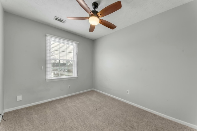 carpeted empty room featuring visible vents, baseboards, a textured ceiling, and a ceiling fan