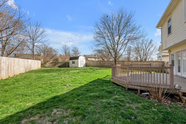 view of yard with an outdoor structure, a fenced backyard, a shed, and a wooden deck