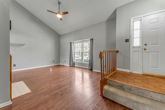 foyer featuring baseboards, high vaulted ceiling, wood finished floors, and a ceiling fan