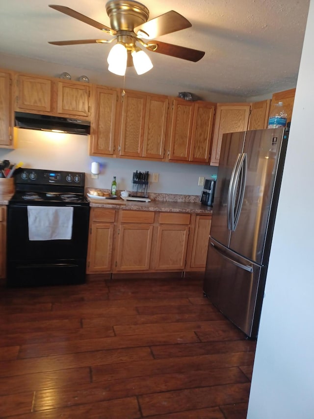 kitchen with black / electric stove, ceiling fan, freestanding refrigerator, dark wood-style floors, and under cabinet range hood