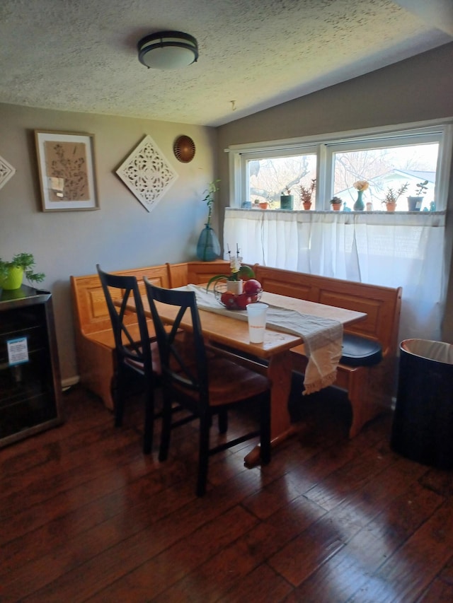 dining room with a textured ceiling, dark wood-style flooring, and breakfast area