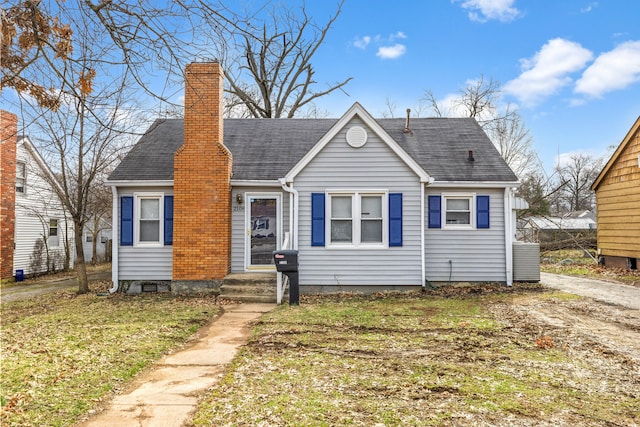 bungalow-style house featuring a chimney and roof with shingles