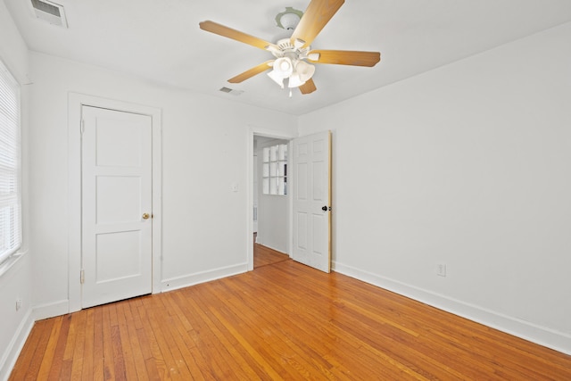 unfurnished bedroom with visible vents, light wood finished floors, baseboards, and multiple windows