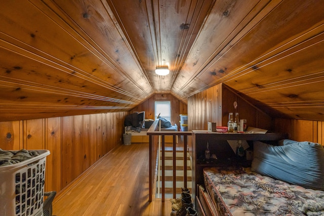 bedroom with wood ceiling, vaulted ceiling, wood walls, and hardwood / wood-style floors