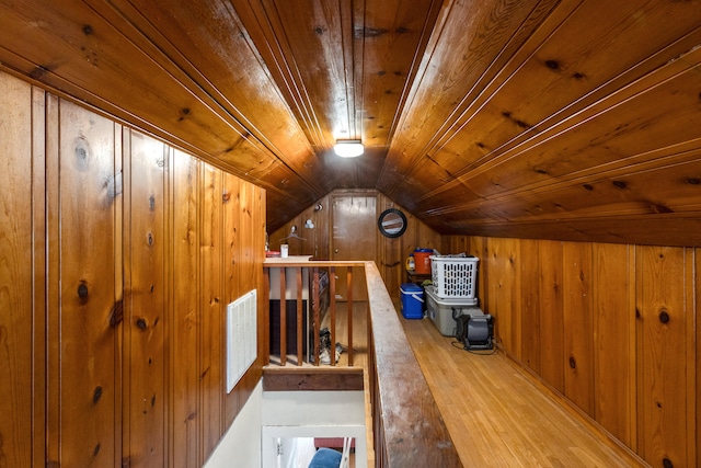 bonus room with lofted ceiling, wooden walls, wood finished floors, visible vents, and wood ceiling