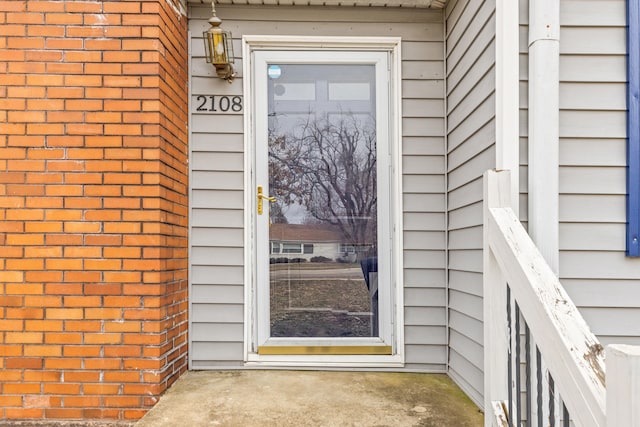 doorway to property featuring brick siding