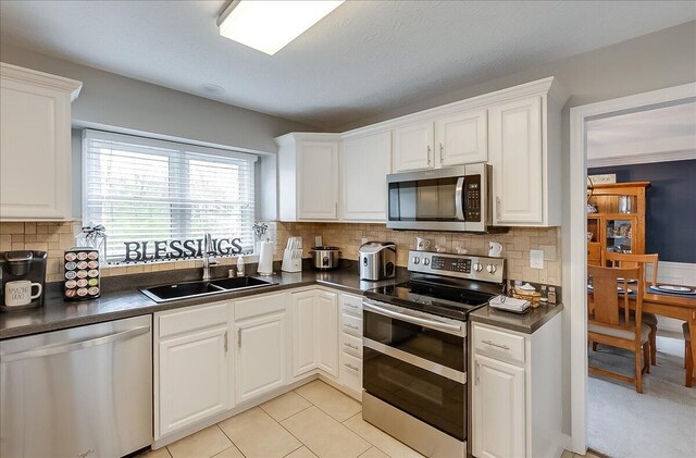 424 Amberley Dr, Lexington, KY 40515 - kitchen with a sink, appliances with stainless steel finishes, dark countertops, white cabinets, and decorative backsplash
