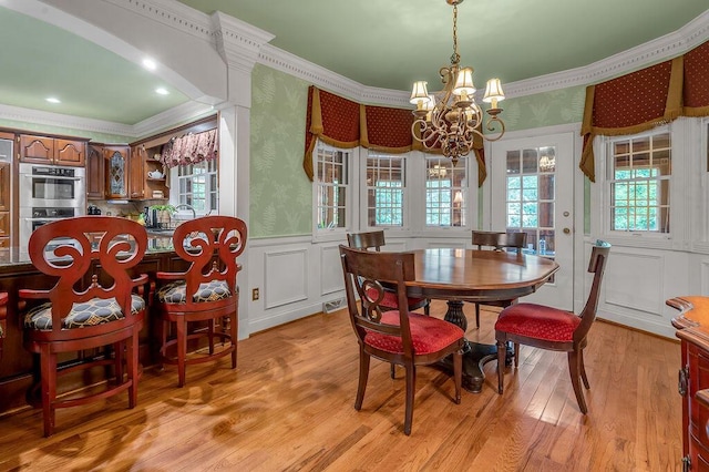 870 Mcmeekin Pl, Lexington, KY 40502 - dining room featuring crown molding, a chandelier, a wainscoted wall, healthy amount of natural light, and light wood-type flooring
