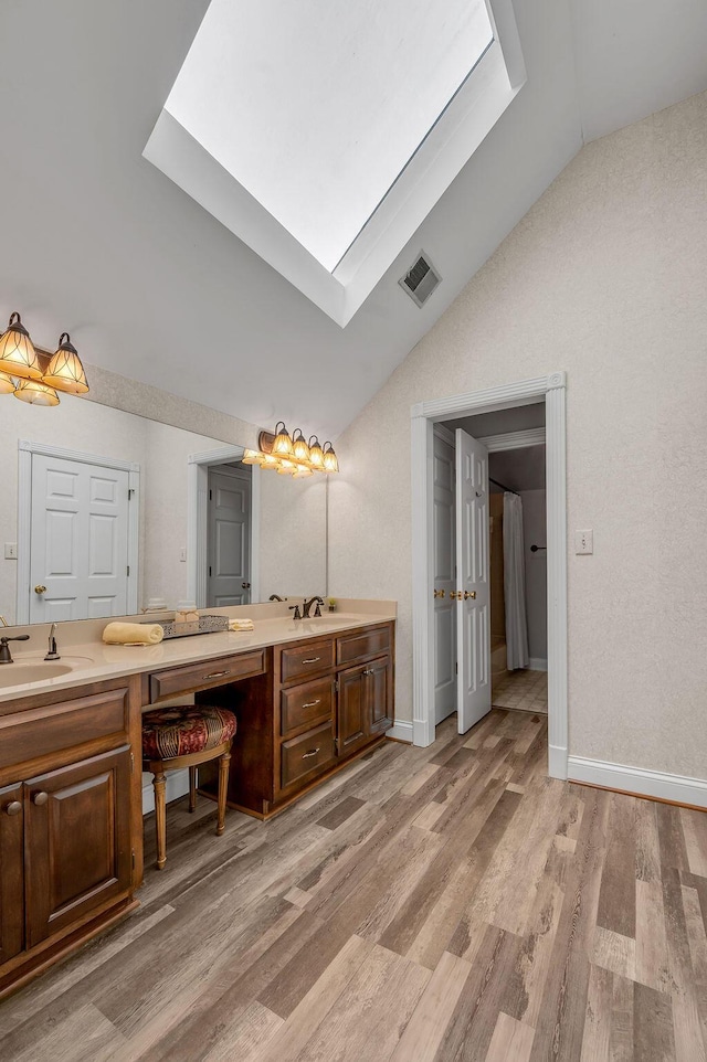 870 Mcmeekin Pl, Lexington, KY 40502 - full bathroom with vaulted ceiling, a skylight, wood finished floors, double vanity, and baseboards